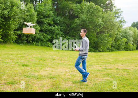 Ufa, Russia. - 6 June 2016 : Air drone carrying cardboard box - concept image of futuristic delivery drone. Stock Photo