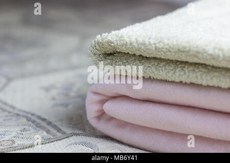 Pink plaid and towel are lying on the bed Stock Photo