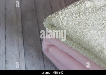 Pink plaid and towel are lying on the bed Stock Photo