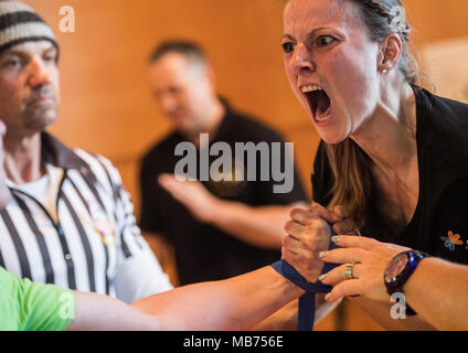 07 April 2018, Germany, Rodenbach: Katrin Mook from the Hanu Armwrestling Club 'Over the Top' shouting at her opponent after her succesful push. The two referees are observing the two athletes. Around 100 athletes are taking part in the 31st championship. Photo: Andreas Arnold/dpa Stock Photo