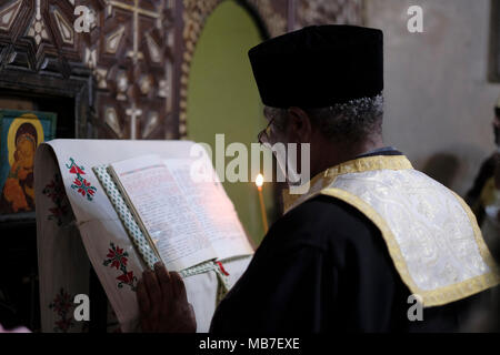 An Ethiopian Orthodox Christian priest pray inside the “Four Animals' chapel  during the Holy Fire ceremony at Deir El-Sultan monastery located on roof of the Church of Holy Sepulchre in the Old City East Jerusalem Israel. Ethiopian Christians commemorate events around the crucifixion of Jesus Christ, leading up to his resurrection on Easter which in the Amharic language, is referred to as Fasika, originated from the Greek word Pascha. Stock Photo