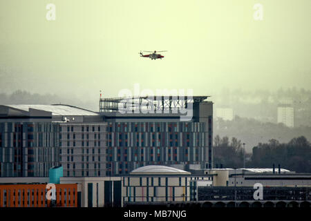 Glasgow, Scotland, UK 8th April. UK Weather: Emergency medical helicopter lands at the Queen Elizabeth University Hospital known locally as the death star because of its helipad in Govan on a miserable wet day with squalid showers. Gerard Ferry/Alamy news Stock Photo