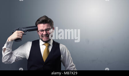 Young lost businessman man shooting his head with gun Stock Photo