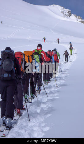 group of backcountry skiers crossing a glacier on their way to a high summit in the Alps Stock Photo