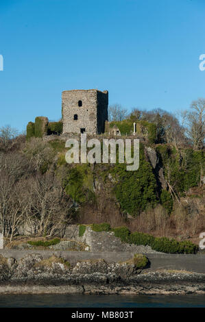 Dunstaffnage Castle & Chapel near Oban on the Western coast of Scotland with snow capped mountains in the distance Stock Photo