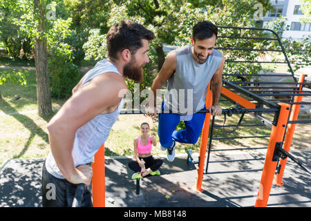 Two muscular young men doing bodyweight exercises in fitness park Stock Photo