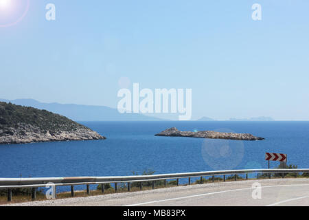 A mountain road serpentine along the blue calm Mediterranean Sea. Stock Photo