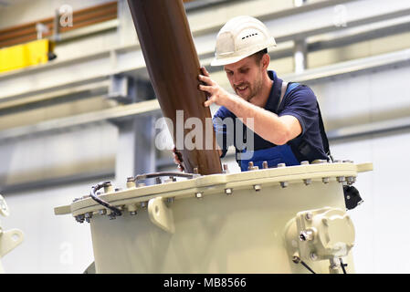 operator installs a transformer in an industrial plant in mechanical engineering Stock Photo