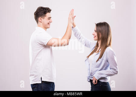 Joyful man and woman greeting each other with a high five isolated on white background Stock Photo