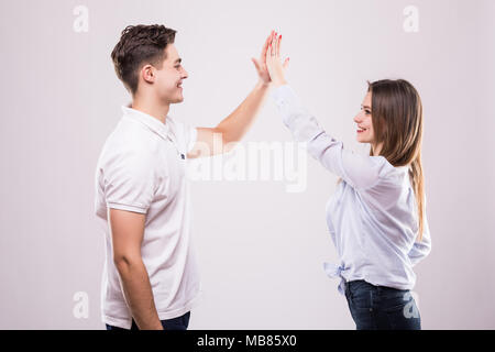 Joyful man and woman greeting each other with a high five isolated on white background Stock Photo