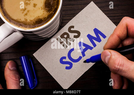 Conceptual hand writing showing Irs Scam. Business photo text Warning Scam Fraud Tax Pishing Spam Money Revenue Alert Scheme written Man Holding Marke Stock Photo