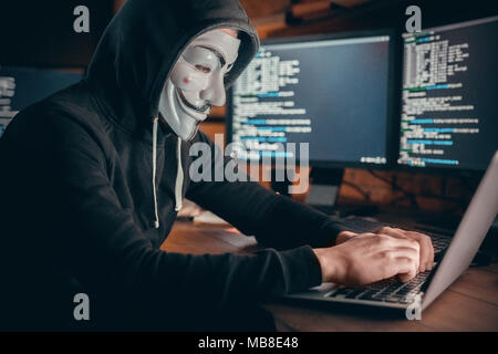 Young man financial hacker at office sitting at table hacking system typing on laptop Stock Photo