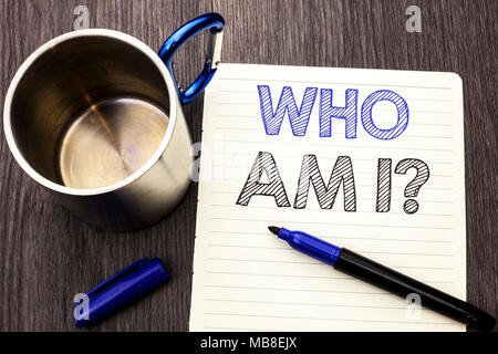 Conceptual hand writing showing Who Am I Question. Business photo showcasing Question Asked Identity Thinking Doubt Psycology Mystery written on Notebook Paper wooden background Marker and Cup Stock Photo