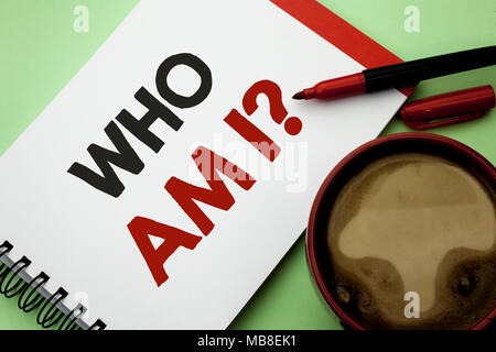 Handwriting text writing Who Am I Question. Concept meaning Question Asked Identity Thinking Doubt Psycology Mystery written on Notebook Book on the plain background Coffee Cup next to it. Stock Photo