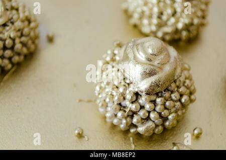 Granulated chocolate brigadier with crunchy balls topped with gold paint and a chocolate flower on top. On a golden tray. Top View. Copy space. Stock Photo