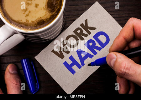 Conceptual hand writing showing Work Hard. Business photo text Struggle Success Effort Ambition Motivation Achievement Action written Man Holding Marker on Note Paper Wooden background Coffee. Stock Photo