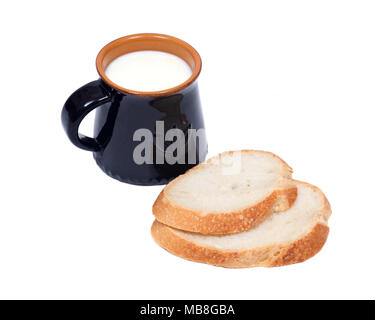 Cream top organic whole milk in ceramic cup and sliced crusty country style round organic french bread Stock Photo