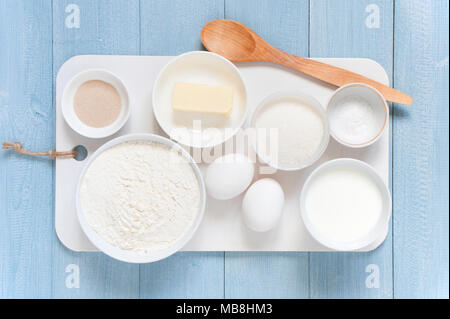 Ingredients for baking end spoon on the textured blue wooden table. Top view Stock Photo