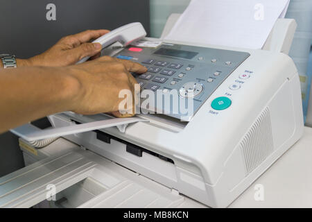 Men are using a fax machine in the office. Business concept Stock Photo