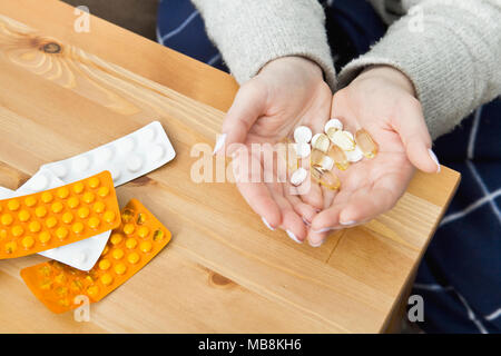 Woman taking medicine capsules at home. Drugs closeup Stock Photo