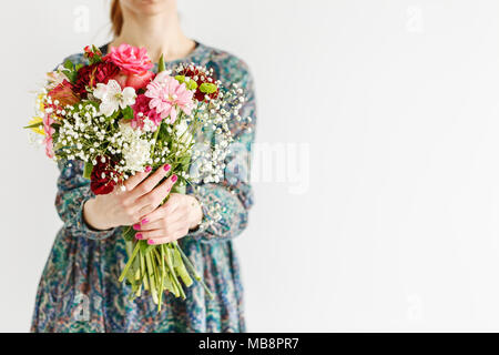 Young woman giving a beautiful bouquet of fresh flowers to her mother for mother's day Stock Photo