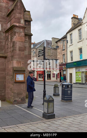 A man waiting at the Street Corner next to St John's Church one Saturday afternoon in Spring in Perth, Perthshire, Scotland. Stock Photo