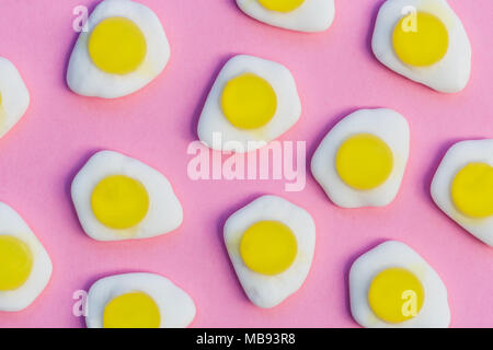 Fried eggs candy sweets on bright pink background Stock Photo