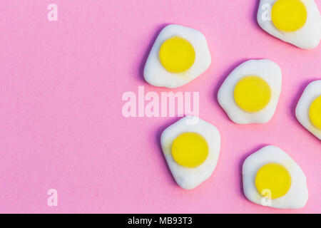 Fried eggs candy sweets on bright pink background with copy space Stock Photo