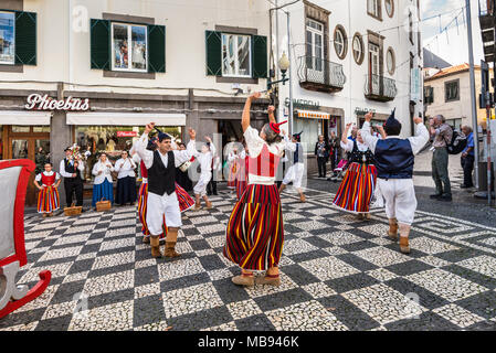 Funchal, Portugal - December 10, 2016: Dancers with local costumes demonstrating a folk dance  on the street in Funchal, Madeira Island, Portugal. Stock Photo