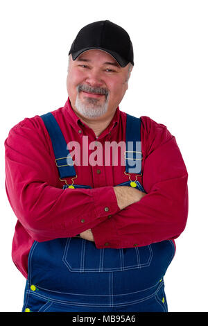 Portrait of happy worker wearing dungarees standing with arms crossed against white background Stock Photo