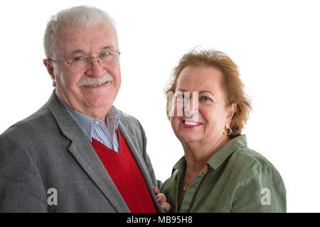 Happy friendly loving senior couple standing close together in an embrace smiling happily at the camera isolated on white Stock Photo