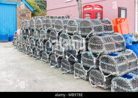 Fisherman's crab and lobster pots stacked up by a shed in the South Hams village of Hope Cove in Devon Stock Photo