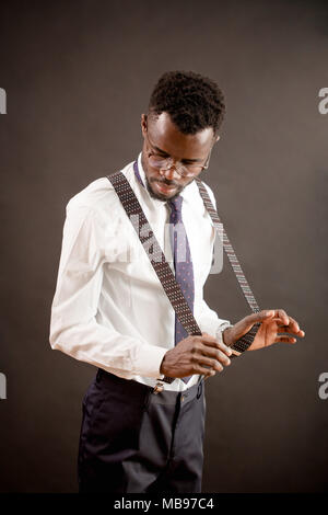 portrait of African male looking at his new trousers with suspenders Stock Photo