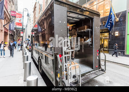 New York City, USA - October 30, 2017: UPS, United Parcel Service, man unloading packages delivery at Broadway St by Wall Street in NYC Manhattan lowe Stock Photo