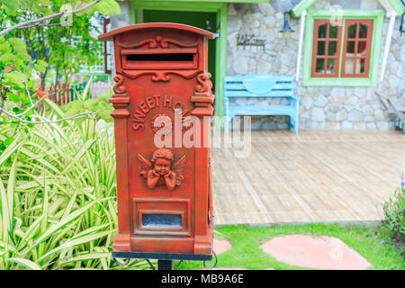 Red old-fashioned mailbox or vintage post box in front of House. Stock Photo