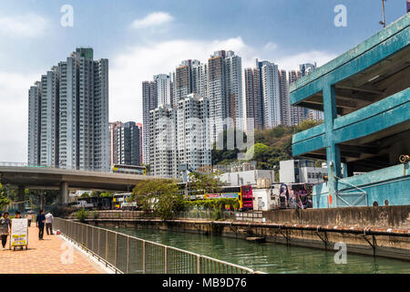 Towering high rise apartments loom over a section of the New World First Bus Services depot in Aberdeen, Hong Kong. Stock Photo