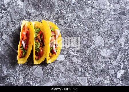 Three Pork Tacos in Shells on Stone Background Stock Photo