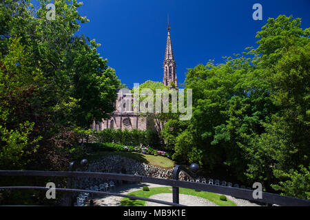 Comillas, Spain - July 3, 2017: View from palace of El Capricho or Villa Quijano by the architect Gaudi in modernist style with tourists in the villag Stock Photo