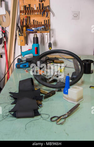 Leather craft or leather working. beautifully black tanned leather on leather craftman's work desk with working tools. Making a leather upholstery for Stock Photo