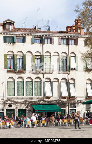 Campo San Polo, San Polo, Venice, Veneto, Italy in spring with people sitting at tables outside the Pizzeria Bar Cico eating and drinking