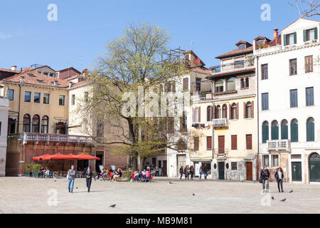 Campo San Polo, San Polo, Venice, Veneto, Italy in spring with local Venetians going about daily life  relaxing in the sunshine Stock Photo