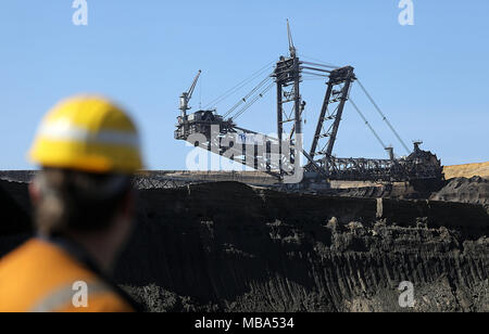 06 April 2018, Germany, Grevenbroich: An employee of RWE Power stands on a bucket wheel excavator at the surface mining Garzweiler in the Rhenish lignite mining region. Photo: Oliver Berg/dpa Stock Photo