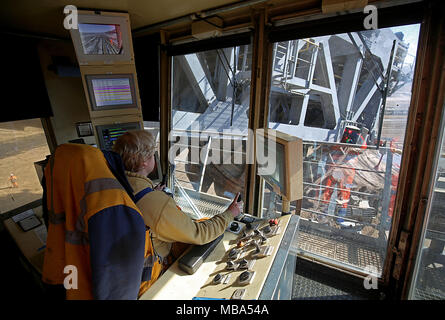 06 April 2018, Germany, Grevenbroich: An employee of RWE Power operates a bucket wheel excavator at the surface mining Garzweiler in the Rhenish lignite mining region. Photo: Oliver Berg/dpa Stock Photo