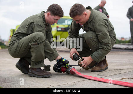 MARINE CORPS AIR STATION FUTENMA, OKINAWA, Japan – Cpl. Daniel Kalinuk, left, and Cpl. Jacob Doerpinghaus secure the nozzles on a hose before a wet run Feb. 10 at the aircraft rescue and firefighting training pit on Marine Corps Air Station Futenma, Okinawa, Japan. ARFF Marines are trained to handle aircraft emergency situations and uphold safety procedures. Kalinuk and Doerpinghaus are ARFF specialists with Headquarters and Headquarters Squadron. (U.S Marine Stock Photo