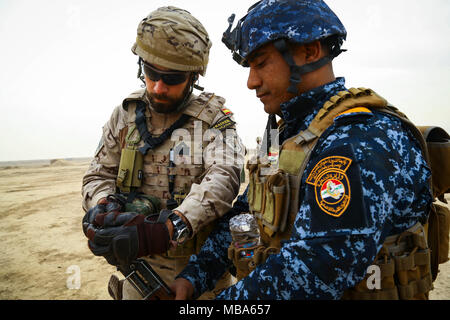 A Spanish trainer assist an Iraqi soldier attached to 1st 
