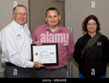 Dan Toland, center, of the Integrated System Evaluation, Experimentation and Test Department at Naval Air Warfare Center Weapons Division, is joined by Terry Williams, left, volunteer and representative of the California Employer Support of the Guard and Reserve program, and 2nd Lt. Charlotte Wilhelm, right, a California National Guardsman and aerospace engineer, as he receives a Patriot Award during a ceremony at China Lake on Feb. 12. (U.S. Navy Stock Photo