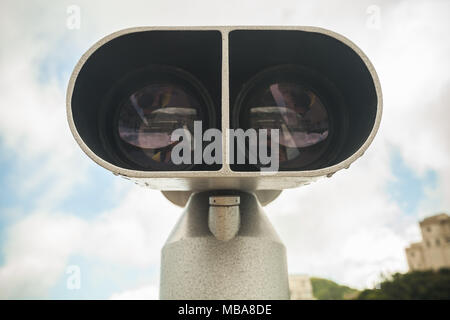 Binocular telescope, closeup vintage toned photo over cloudy sky background Stock Photo