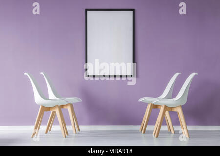 Minimal modern interior with blank poster mockup on the purple wall and white chairs facing each other Stock Photo