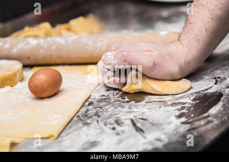The chef's hands prepare dough for pasta. Stock Photo