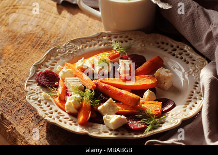 Healthy grilled beet, carrots salad with cheese feta, fennel and Greek yogurt in small glass bowls on the rustic wooden table, top view. Stock Photo